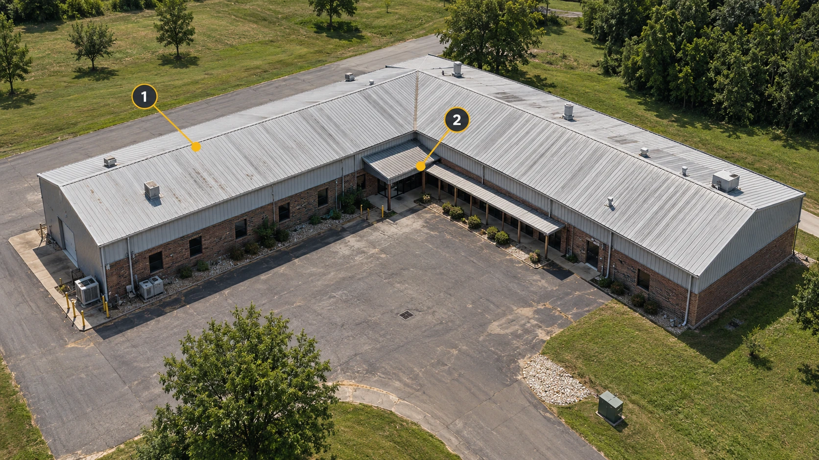 An oblique view of an L-shaped factory: 1 marks the roof; 2 marks the inner corner, canopy and covered walkway.