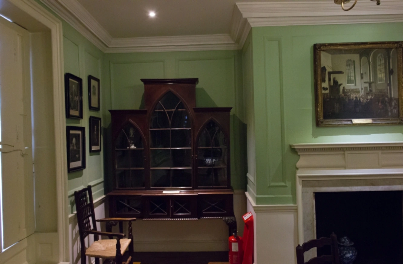 Original photograph: The wooden cabinet, white fireplace, and green walls in Dr Johnson