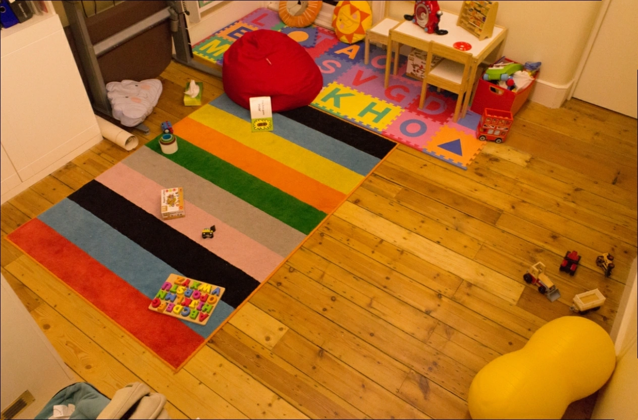 Original photograph: The striped rug, toys, and wooden floor in Playroom